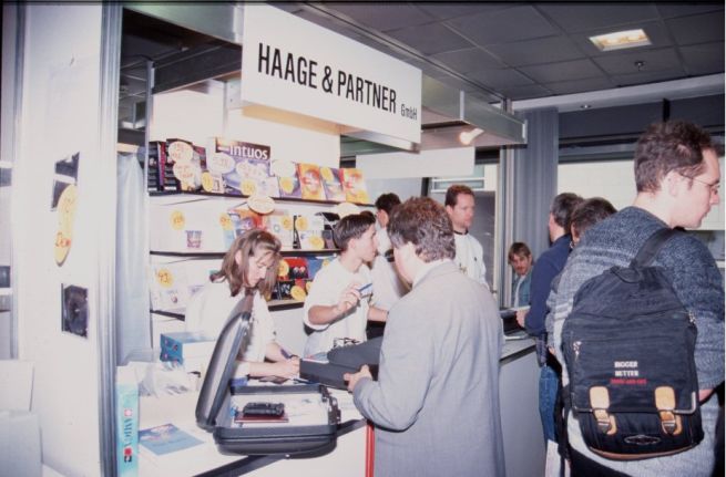 36: Still lots of business at H&P's stand. Gudrun Haage, Michael Kinch, Jürgen Haage (background, back turned), and Markus Nerding.